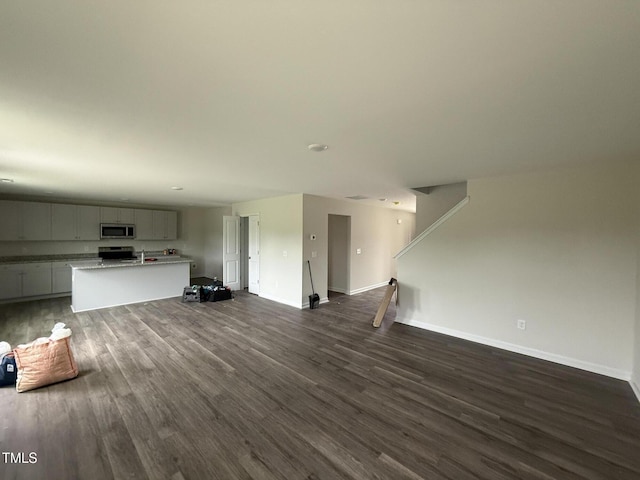 43 Chloe Ct, Selma, NC 27577 - unfurnished living room with dark wood-style flooring and baseboards