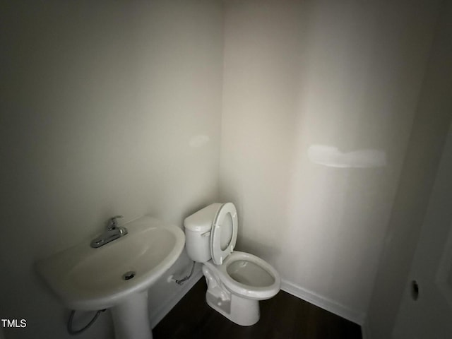 43 Chloe Ct, Selma, NC 27577 - half bath featuring toilet, baseboards, wood finished floors, and a sink