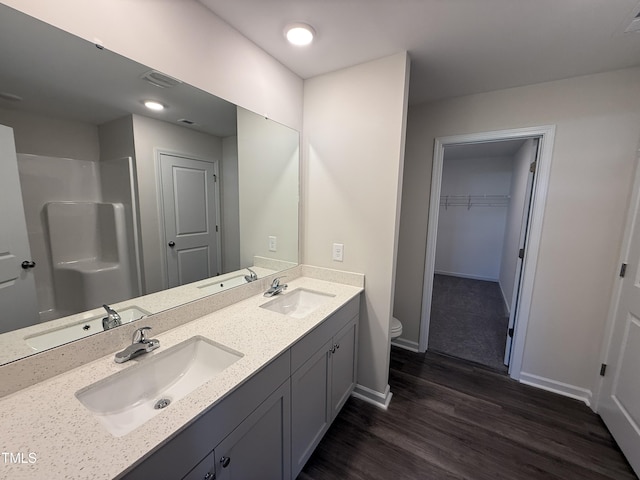43 Chloe Ct, Selma, NC 27576 - bathroom with wood finished floors, double vanity, a spacious closet, and a shower