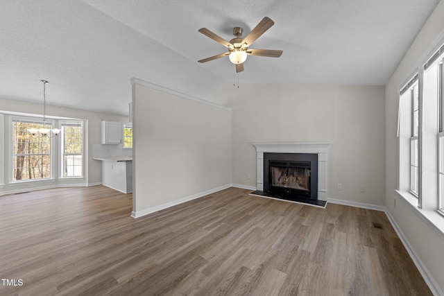5408 Rivercrest Dr, Youngsville, NC 27596 - unfurnished living room with ceiling fan with notable chandelier, baseboards, visible vents, a fireplace, and wood finished floors