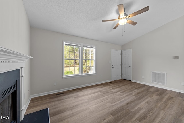 5408 Rivercrest Dr, Youngsville, NC 27596 - unfurnished living room with lofted ceiling, a fireplace with flush hearth, visible vents, a ceiling fan, and wood finished floors