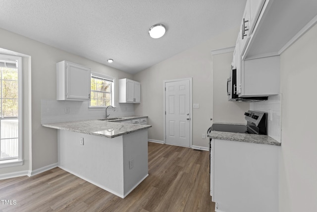 5408 Rivercrest Dr, Youngsville, NC 27596 - kitchen featuring backsplash, a sink, white cabinetry, wood finished floors, and a peninsula
