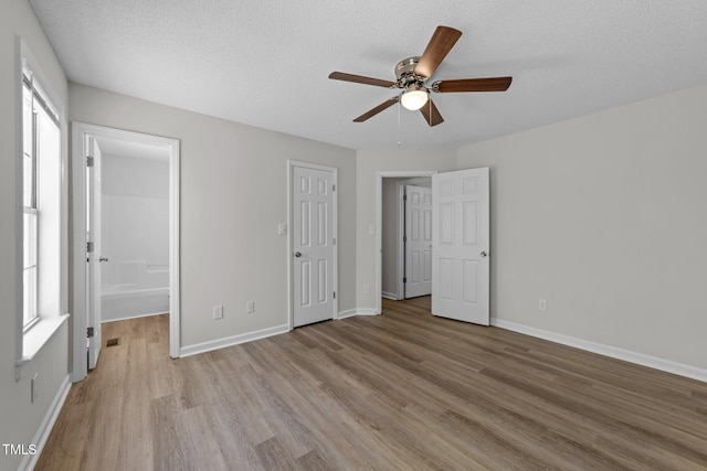 5408 Rivercrest Dr, Youngsville, NC 27596 - unfurnished bedroom featuring a textured ceiling, visible vents, baseboards, wood finished floors, and a ceiling fan