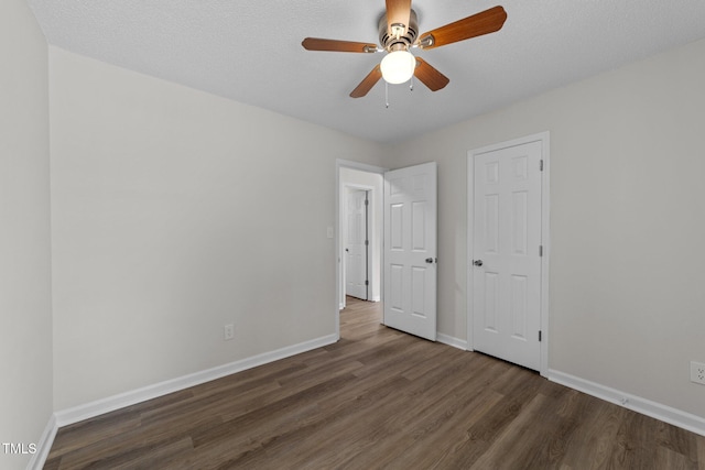 5408 Rivercrest Dr, Youngsville, NC 27596 - unfurnished bedroom with dark wood-type flooring, a textured ceiling, baseboards, and a ceiling fan