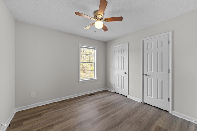 5408 Rivercrest Dr, Youngsville, NC 27596 - unfurnished bedroom with a ceiling fan, a textured ceiling, baseboards, visible vents, and dark wood-style flooring