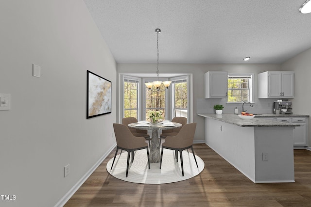 5408 Rivercrest Dr, Youngsville, NC 27596 - dining space with dark wood-type flooring, baseboards, and a chandelier