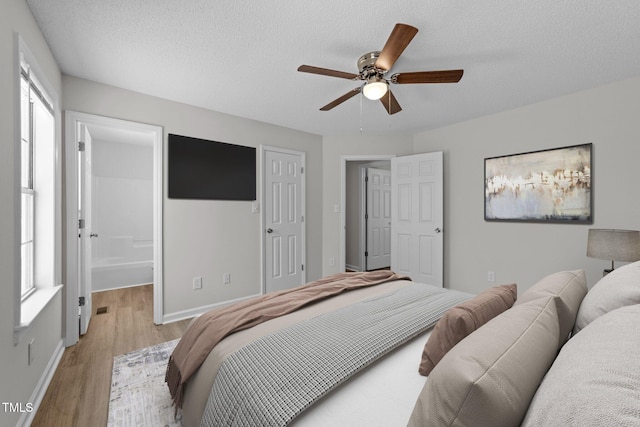 5408 Rivercrest Dr, Youngsville, NC 27596 - bedroom with baseboards, light wood-style floors, ceiling fan, and a textured ceiling