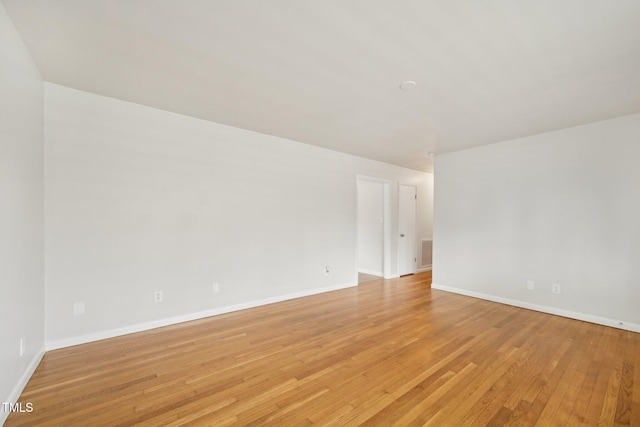 unfurnished room with light wood-style flooring, baseboards, and visible vents