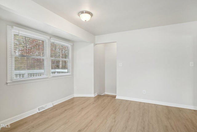 empty room with visible vents, baseboards, and wood finished floors