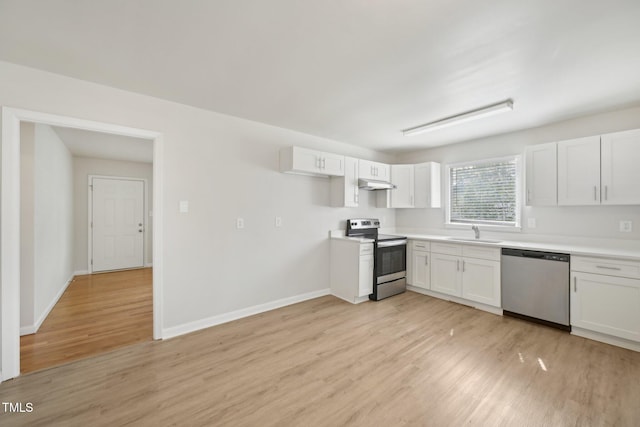 kitchen with white cabinets, under cabinet range hood, a sink, stainless steel appliances, and light wood finished floors