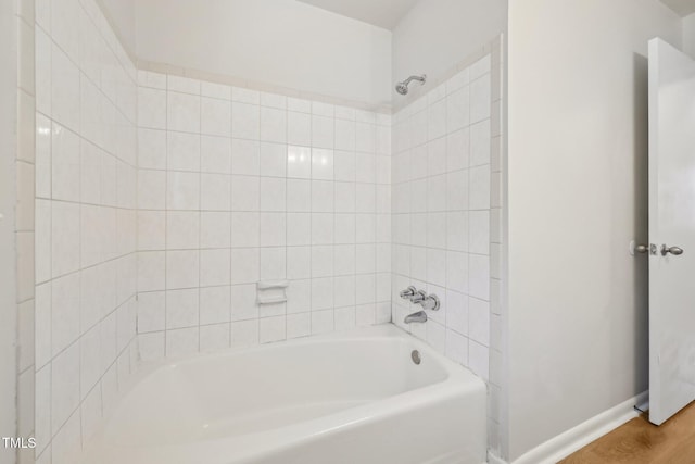 full bath featuring baseboards, wood finished floors, and  shower combination