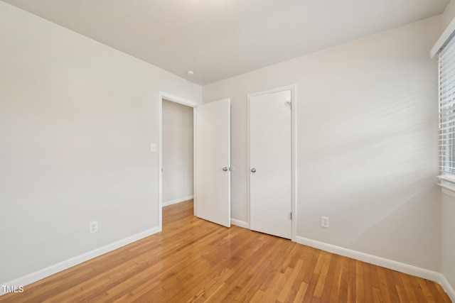 unfurnished bedroom with light wood finished floors and baseboards