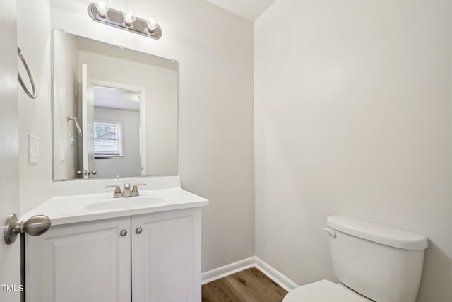 bathroom featuring vanity, baseboards, toilet, and wood finished floors