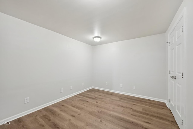 empty room with baseboards and wood finished floors