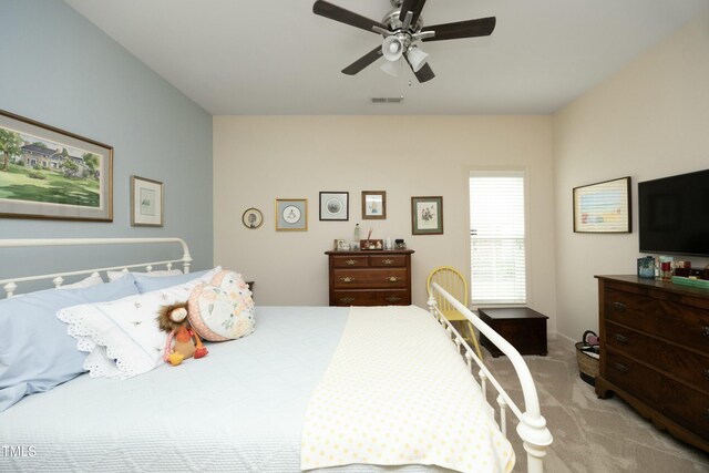 bedroom featuring light colored carpet, visible vents, and a ceiling fan