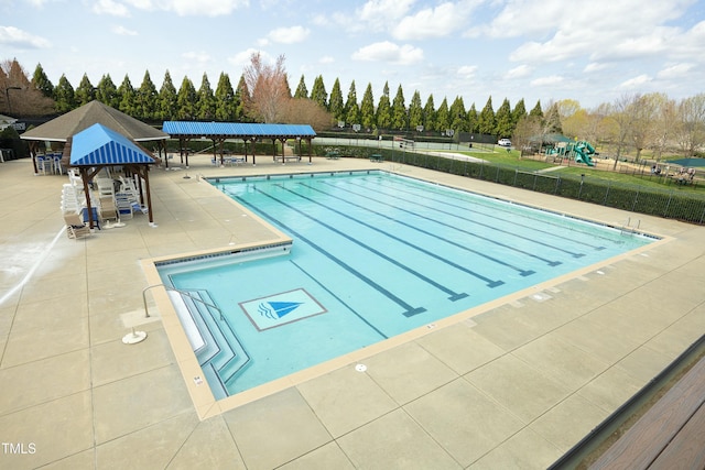 community pool featuring fence and a patio