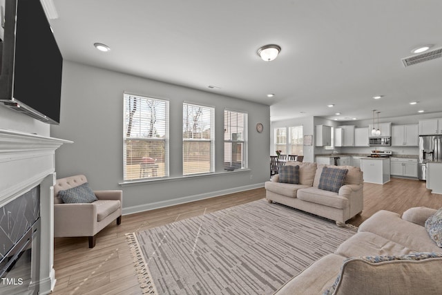 1408 Weavers Trace Dr, Zebulon, NC 27597 - living area featuring a fireplace, light wood-type flooring, baseboards, visible vents, and recessed lighting