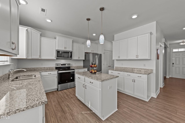 1408 Weavers Trace Dr, Zebulon, NC 27597 - kitchen featuring a sink, light wood-style floors, visible vents, white cabinets, and appliances with stainless steel finishes
