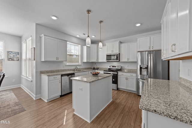 1408 Weavers Trace Dr, Zebulon, NC 27597 - kitchen with a sink, a kitchen island, light wood-style flooring, stainless steel appliances, and white cabinets
