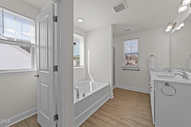 1408 Weavers Trace Dr, Zebulon, NC 27597 - full bathroom with wood finished floors, a sink, a bath, and visible vents
