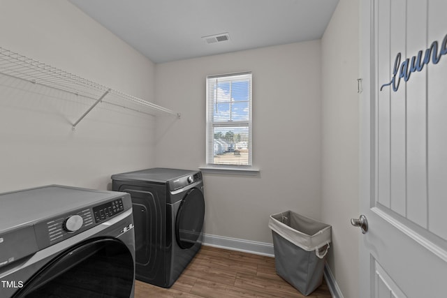 1408 Weavers Trace Dr, Zebulon, NC 27597 - clothes washing area with visible vents, baseboards, wood finished floors, laundry area, and separate washer and dryer