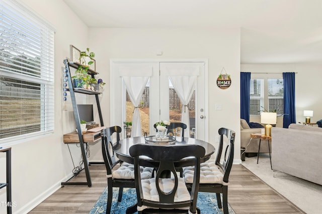 dining room featuring baseboards and light wood-style flooring