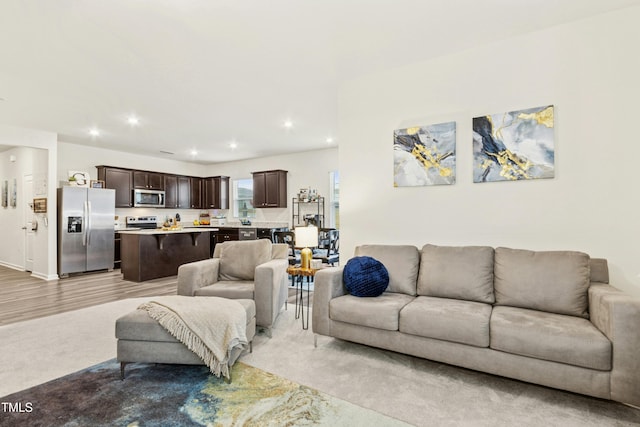 living area featuring light wood-style flooring and recessed lighting