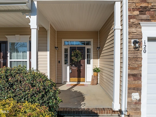 view of exterior entry featuring covered porch
