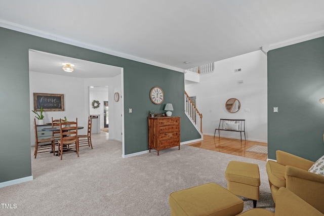 living area featuring baseboards, carpet floors, and stairway
