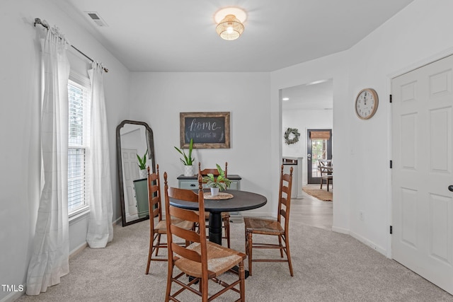 dining space with light carpet, baseboards, and visible vents