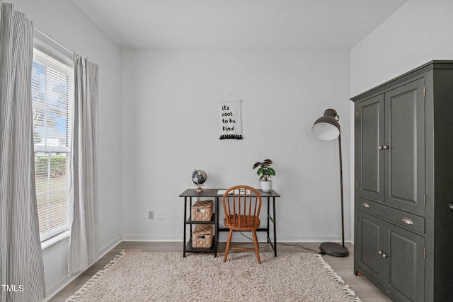 office space with baseboards and light wood finished floors