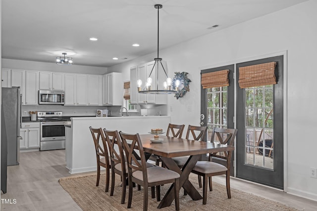 dining area featuring recessed lighting, light wood-type flooring, visible vents, and a notable chandelier