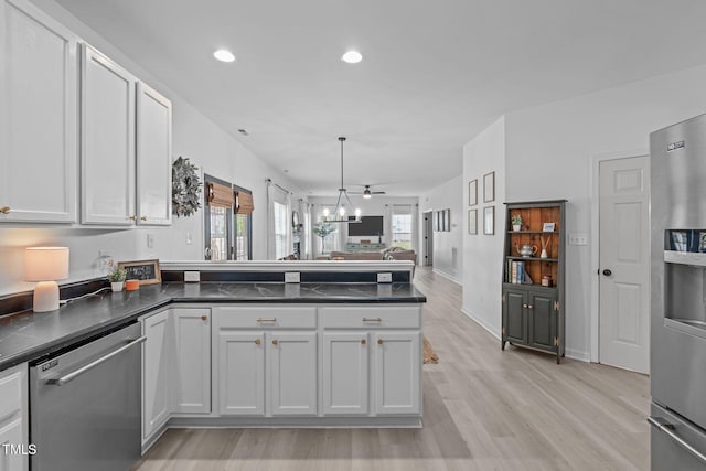 kitchen with stainless steel appliances, dark countertops, a peninsula, light wood-style flooring, and open floor plan