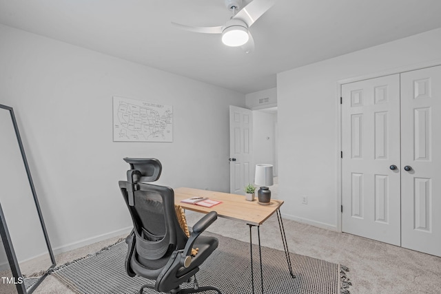 office space featuring baseboards, a ceiling fan, visible vents, and carpet