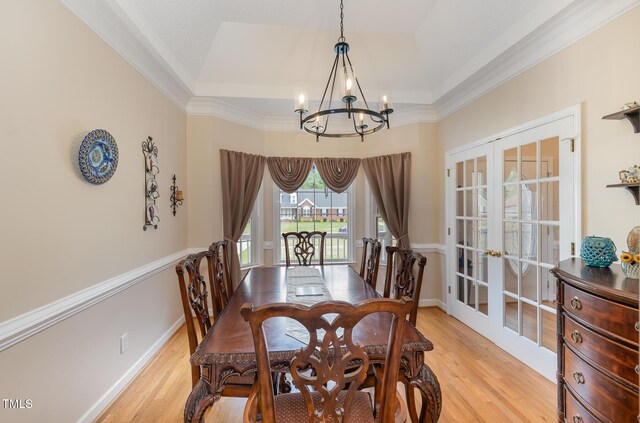 608 Adler Ln, Goldsboro, NC 27530 - dining room featuring french doors, a notable chandelier, a tray ceiling, and light wood-type flooring
