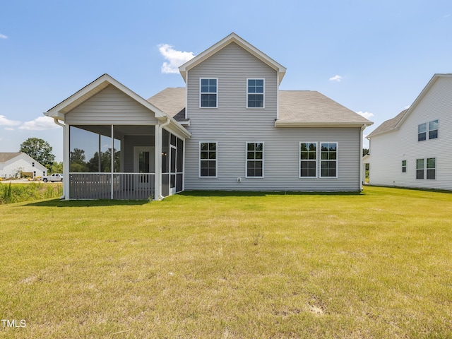 rear view of house with a lawn, a shingled roof, and a sunroom