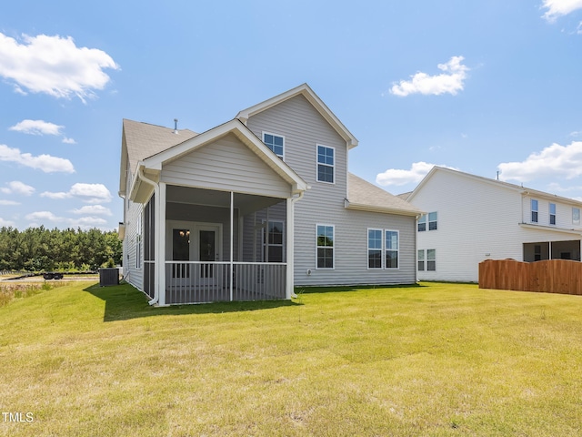 back of house featuring a lawn, cooling unit, a shingled roof, and a sunroom