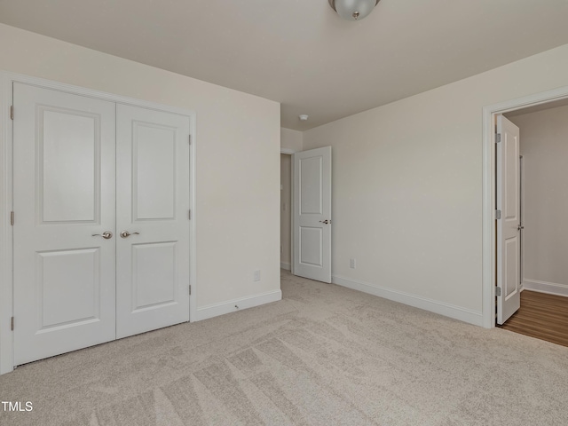 unfurnished bedroom with baseboards, carpet, and a closet