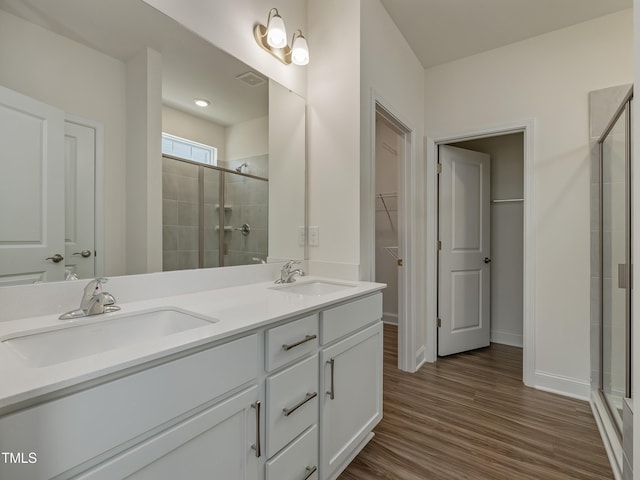 full bath with a sink, a walk in closet, and a shower stall
