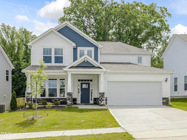 craftsman house with an attached garage, stone siding, a front yard, cooling unit, and driveway