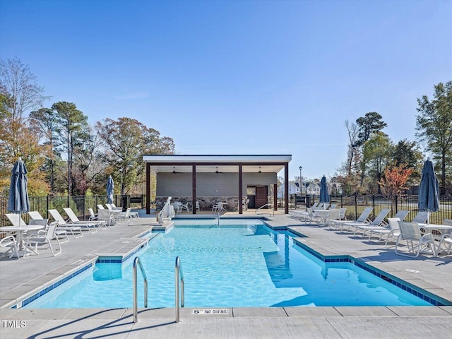 community pool featuring fence and a patio area