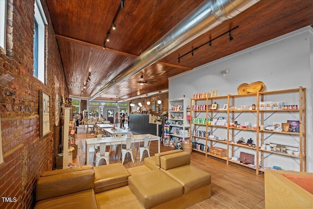 interior space with wooden ceiling, a ceiling fan, rail lighting, and wood finished floors