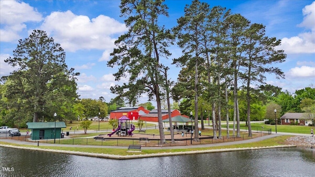 communal playground featuring a water view, fence, and a yard