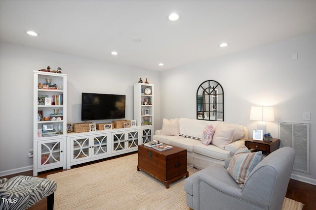 living room featuring baseboards, visible vents, wood finished floors, and recessed lighting