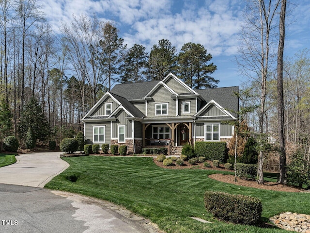 107 Bella Casa Way, Clayton, NC 27527 - craftsman house with concrete driveway, stone siding, board and batten siding, a front yard, and a porch