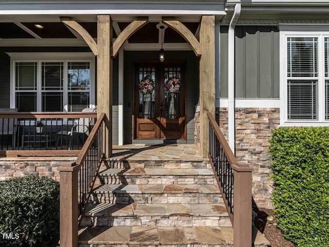 107 Bella Casa Way, Clayton, NC 27527 - view of exterior entry featuring covered porch, stone siding, and board and batten siding