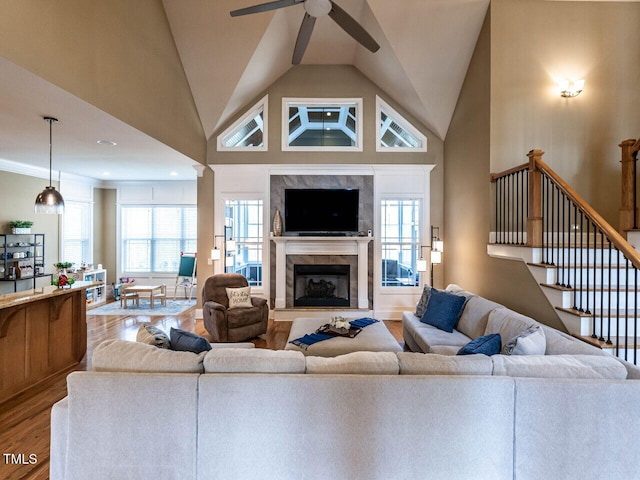 107 Bella Casa Way, Clayton, NC 27527 - living area with stairway, high vaulted ceiling, ceiling fan, a high end fireplace, and wood finished floors
