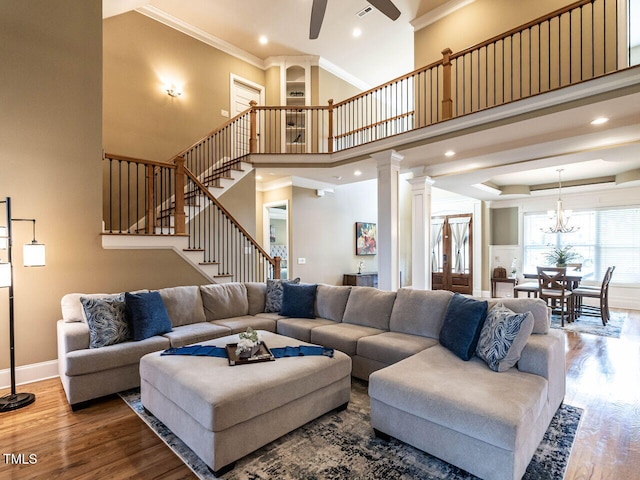 107 Bella Casa Way, Clayton, NC 27527 - living area featuring ceiling fan with notable chandelier, crown molding, stairs, and wood finished floors