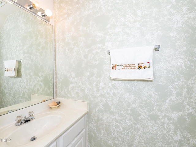 bathroom with wallpapered walls and vanity