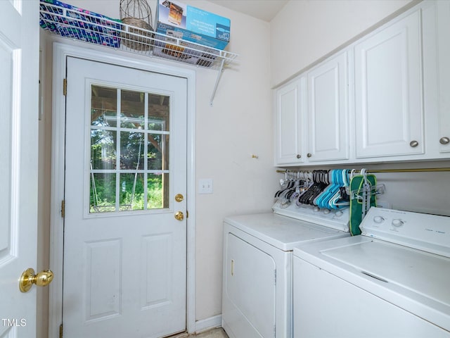 washroom featuring cabinet space and washer and clothes dryer